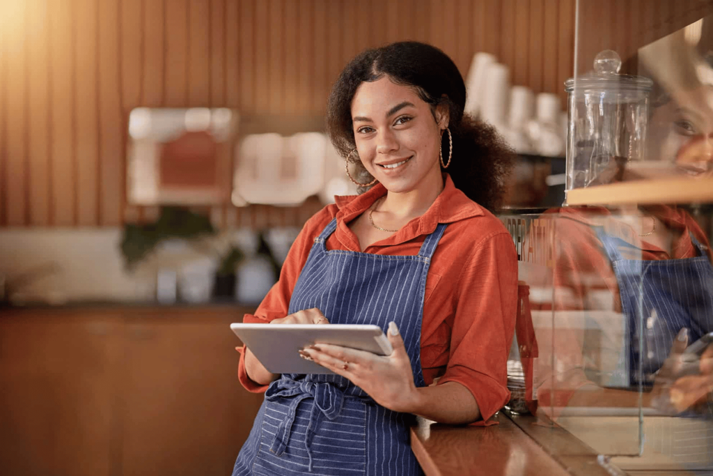 Barista usando una tableta para gestionar pedidos en cafetería