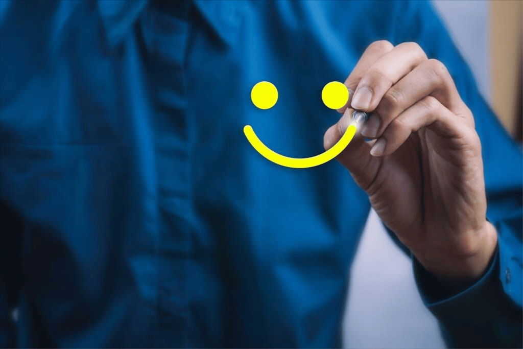Persona dibujando una cara feliz en pantalla transparente